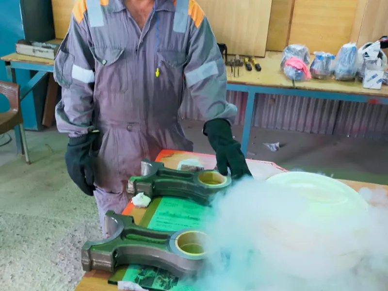 Technician shrink fitting connecting rod bushings with liquid nitrogen